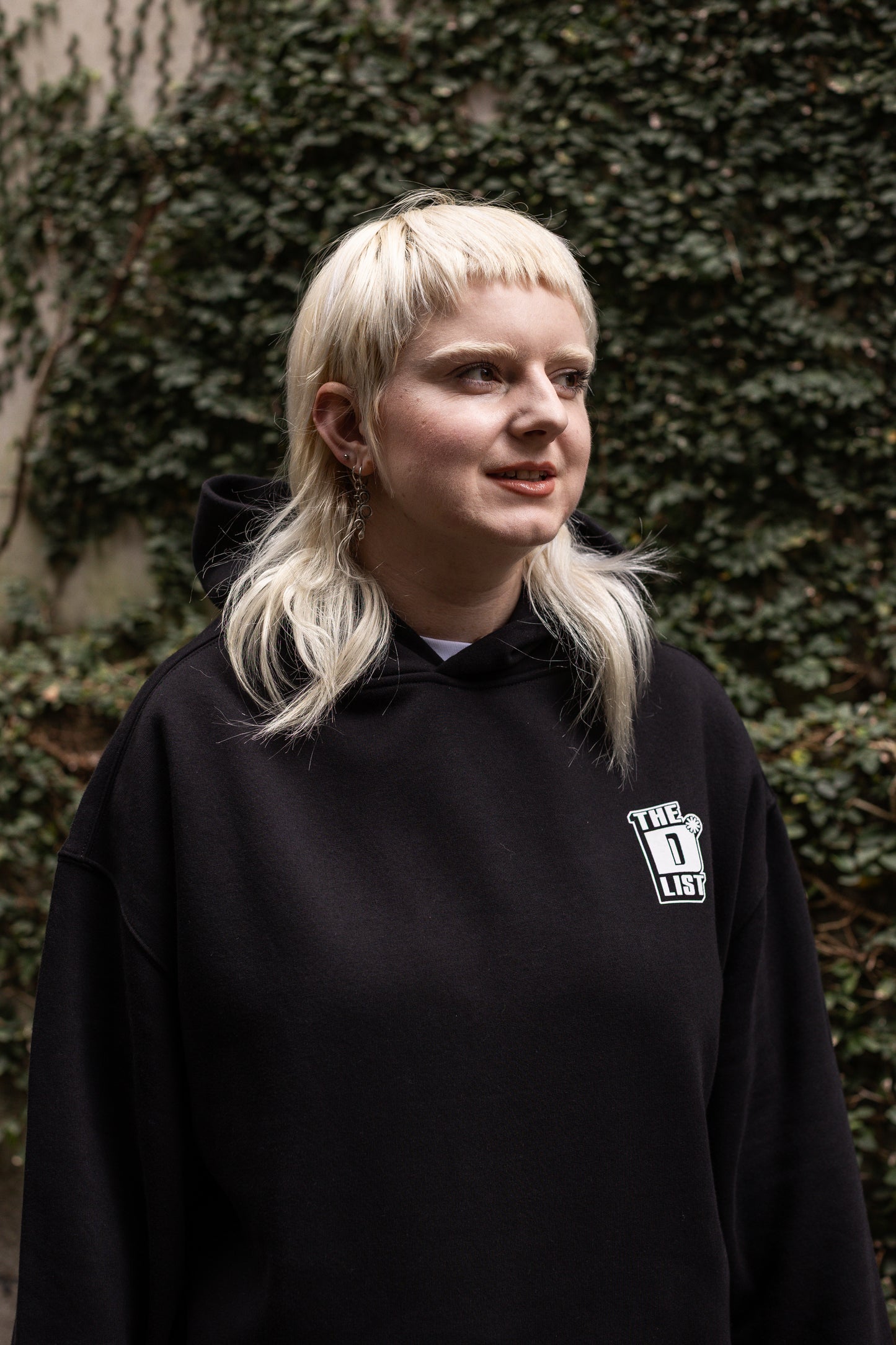 Von wearing a black hoodie with a white "The D*List" logo on the left chest, against a textured wall background