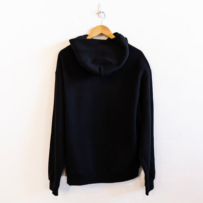 The back of a black hoodie on a hanger against a white background
