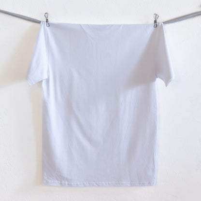 The back of a white t-shirt hangs on a grey ribbon against a white wall