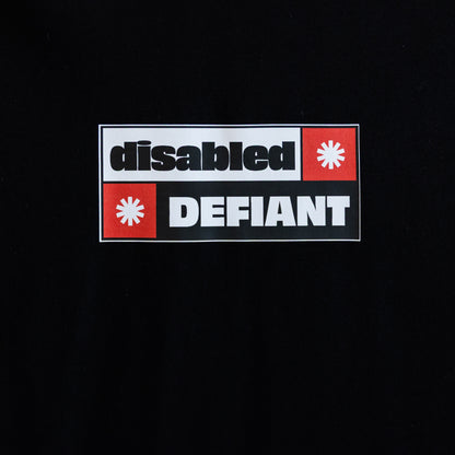 Close up of the print on a black T-shirt with "disabled, DEFIANT" in bold text. The design is black, red and white, and features two tohuwhetū.